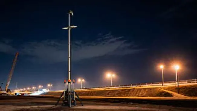 Torre GD-500 con el mástil extendido iluminando un frente de obra vial de noche