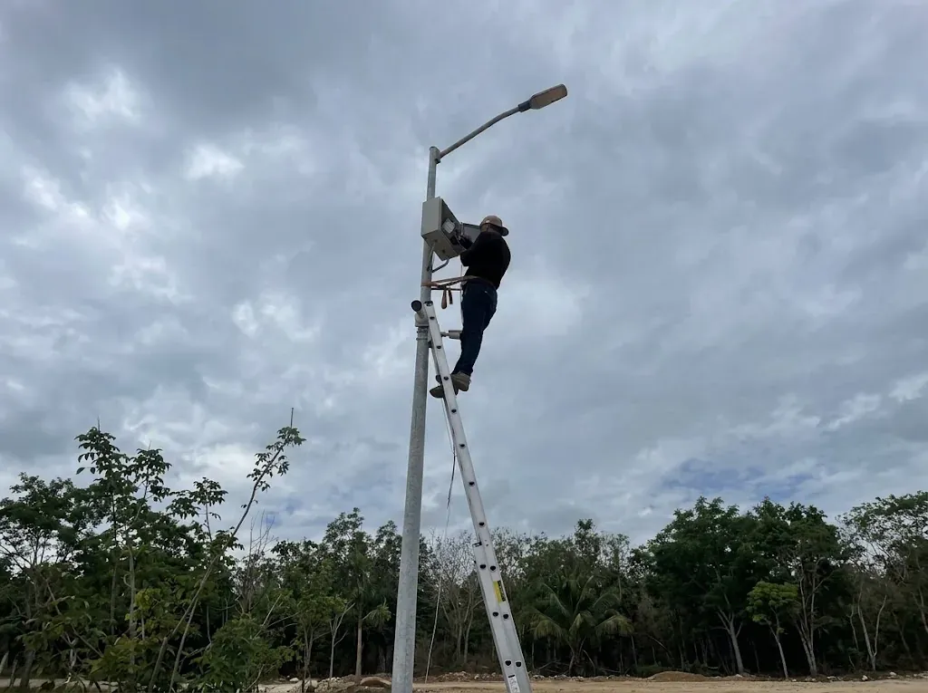 Technician installing a camera and cabinet on a pole